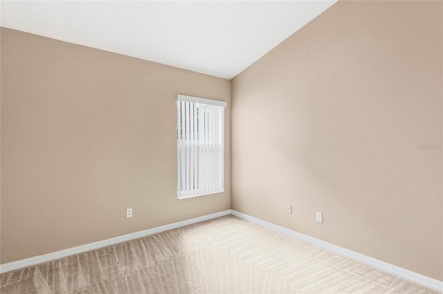 empty room with light carpet and lofted ceiling