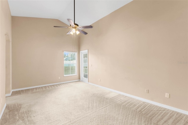 carpeted empty room featuring ceiling fan and high vaulted ceiling