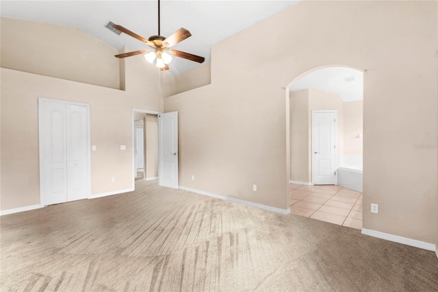 carpeted empty room featuring ceiling fan and high vaulted ceiling