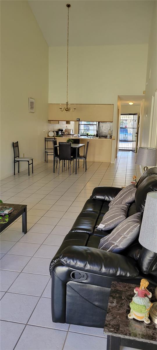 tiled living room featuring high vaulted ceiling