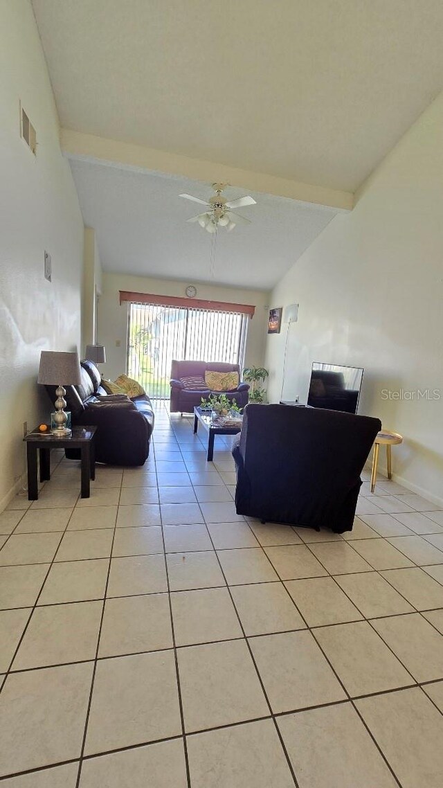 living room featuring lofted ceiling with beams, light tile patterned flooring, and ceiling fan