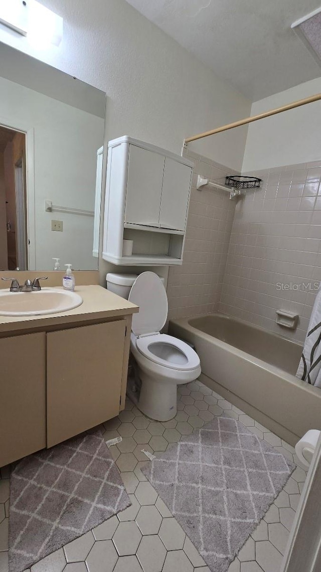 full bathroom with vanity, shower / bath combo with shower curtain, toilet, and tile patterned flooring