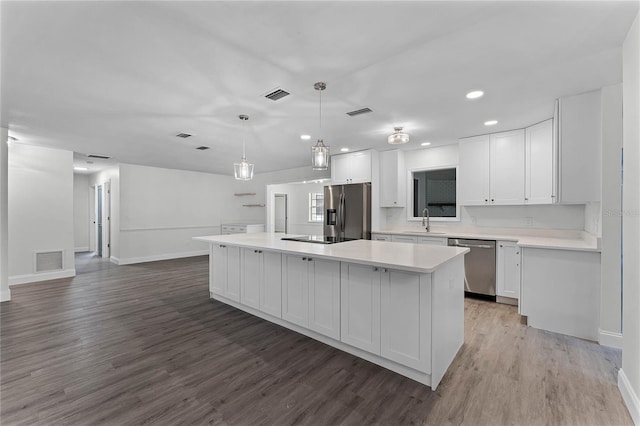 kitchen featuring a kitchen island, white cabinets, and appliances with stainless steel finishes