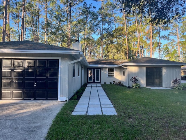 ranch-style home with a garage, french doors, and a front lawn