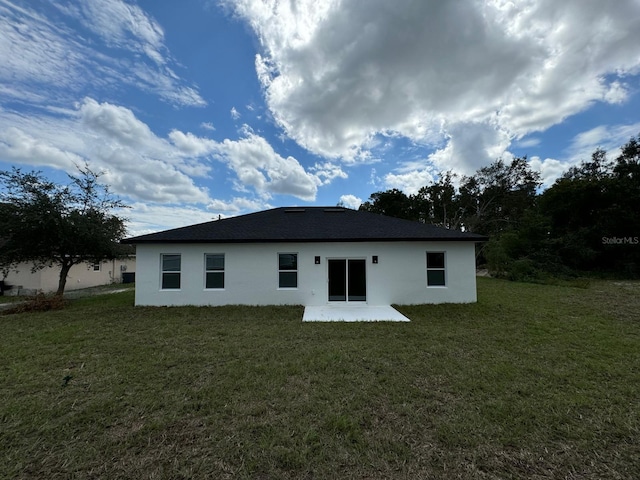 6895 SW 130th Ln, Ocala, FL 34473 - rear view of house featuring stucco siding, a patio area, and a lawn