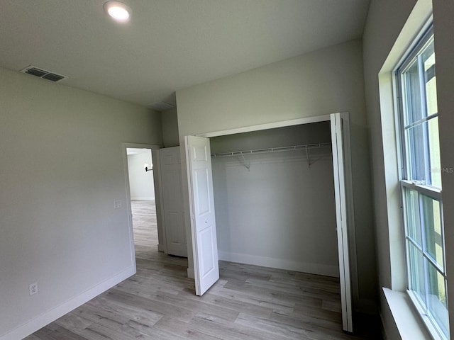 6895 SW 130th Ln, Ocala, FL 34473 - unfurnished bedroom with multiple windows, light wood-style floors, baseboards, and a closet