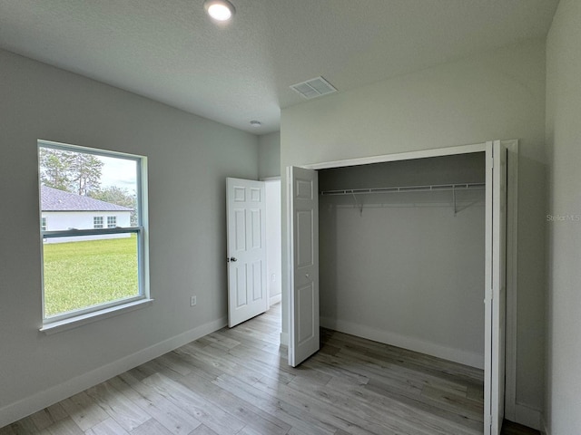 6895 SW 130th Ln, Ocala, FL 34473 - unfurnished bedroom with light wood-type flooring, a closet, and baseboards