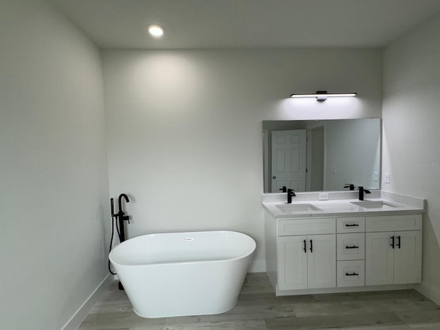 6895 SW 130th Ln, Ocala, FL 34473 - bathroom featuring double vanity, a freestanding tub, baseboards, wood finished floors, and recessed lighting