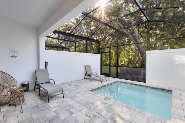 view of pool with glass enclosure and a patio