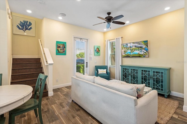 living room with ceiling fan and dark wood-type flooring