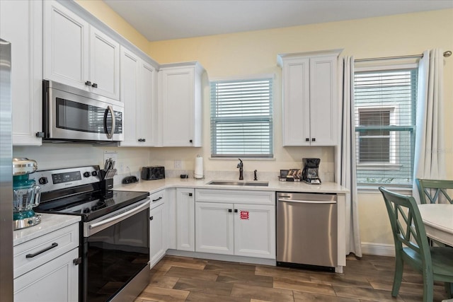 kitchen with white cabinets, stainless steel appliances, dark wood-type flooring, and sink