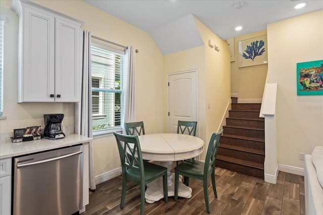 dining area featuring lofted ceiling and dark wood-type flooring