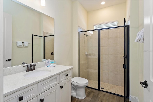 bathroom with vanity, walk in shower, hardwood / wood-style floors, and toilet