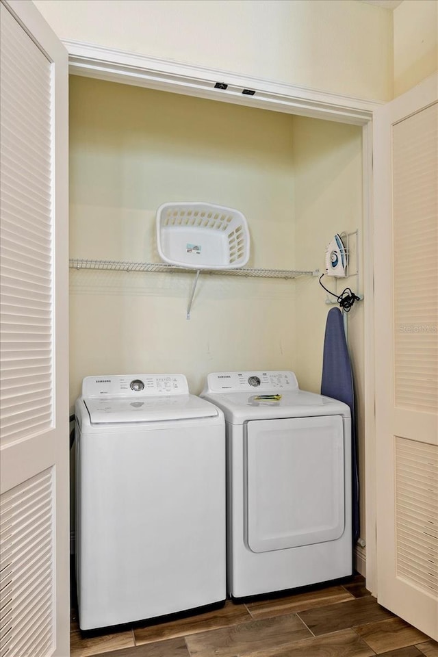 clothes washing area featuring dark hardwood / wood-style floors and separate washer and dryer