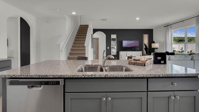 kitchen featuring dishwasher, light stone countertops, and gray cabinets