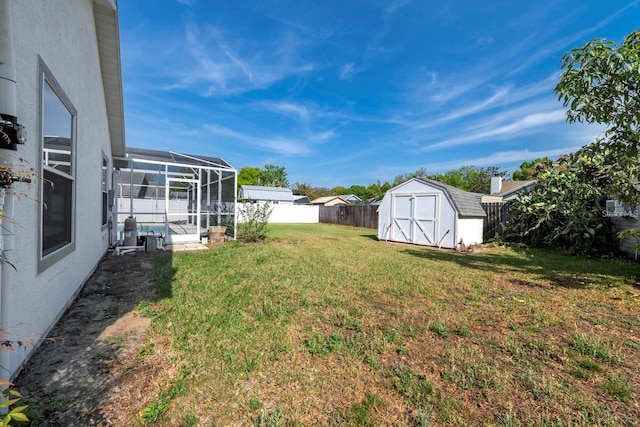 view of yard featuring a storage unit, a lanai, and a patio area