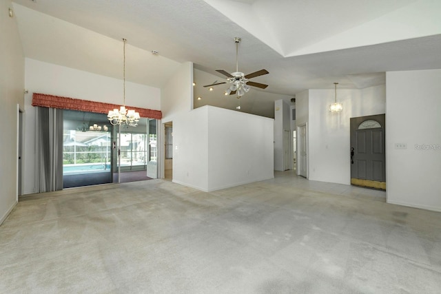 unfurnished living room with high vaulted ceiling, light colored carpet, and ceiling fan with notable chandelier