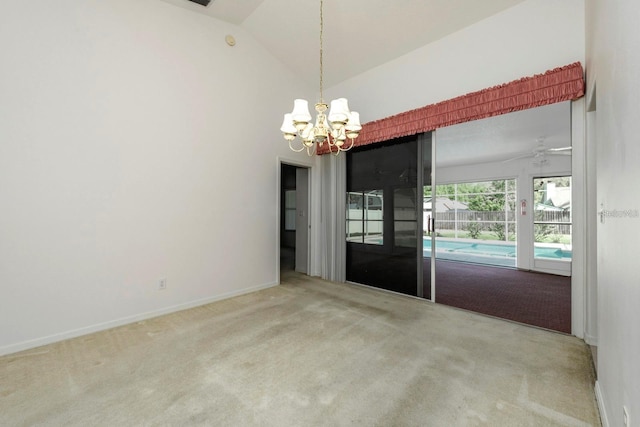 carpeted empty room with ceiling fan with notable chandelier and vaulted ceiling