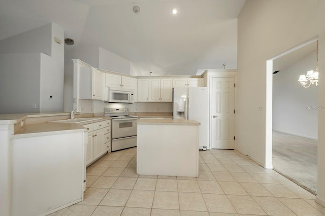 kitchen featuring kitchen peninsula, sink, white appliances, decorative light fixtures, and light colored carpet