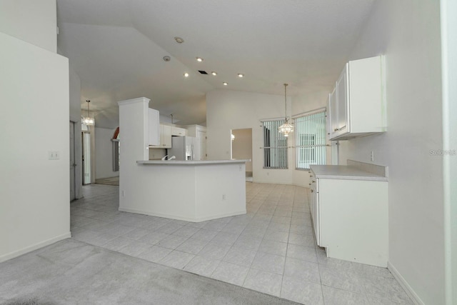 kitchen featuring lofted ceiling, white cabinetry, white refrigerator with ice dispenser, and kitchen peninsula