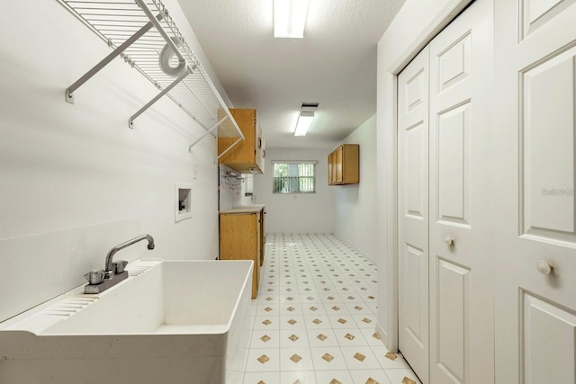 laundry room featuring washer hookup, cabinets, and sink