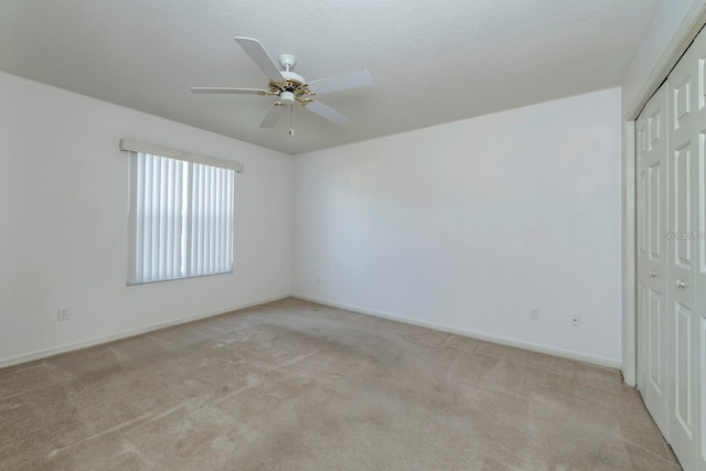 unfurnished room with light carpet, ceiling fan, and a textured ceiling