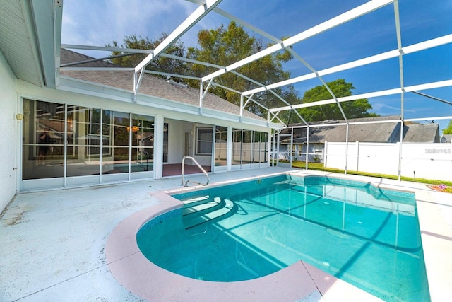 view of swimming pool featuring glass enclosure and a patio area