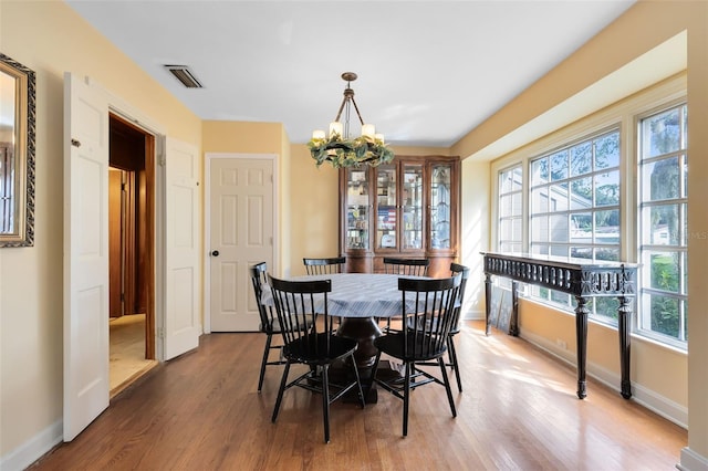 dining room featuring hardwood / wood-style floors and a chandelier