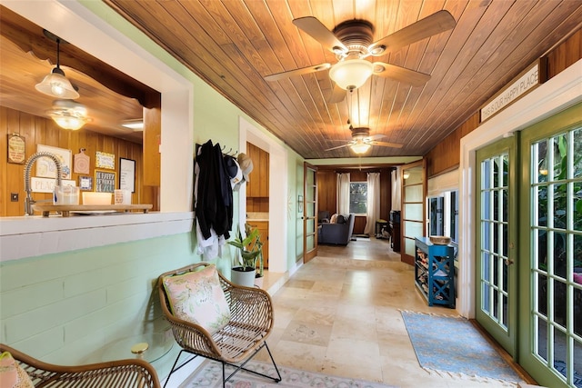 interior space with wood ceiling, french doors, and wooden walls