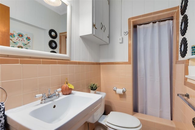 bathroom with toilet, tile walls, sink, and a shower with shower curtain