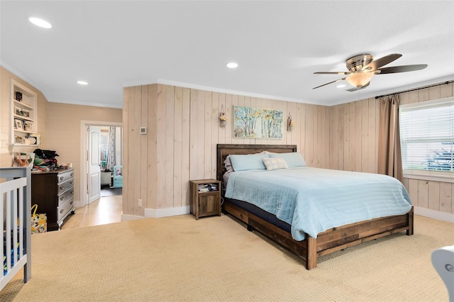 bedroom featuring wood walls, crown molding, and ceiling fan