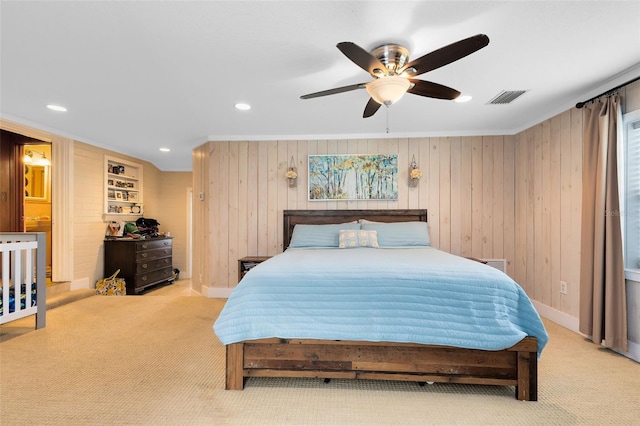 bedroom featuring light carpet, crown molding, wood walls, and ceiling fan