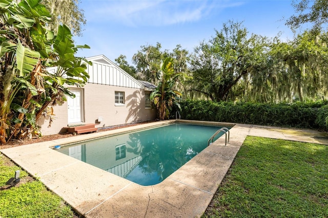 view of swimming pool featuring a lawn