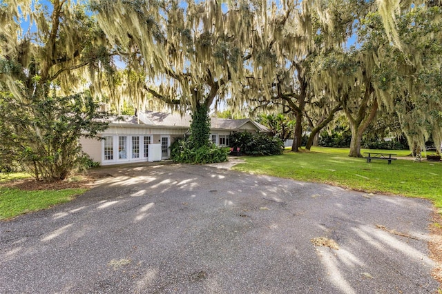 view of front of home with french doors and a front lawn