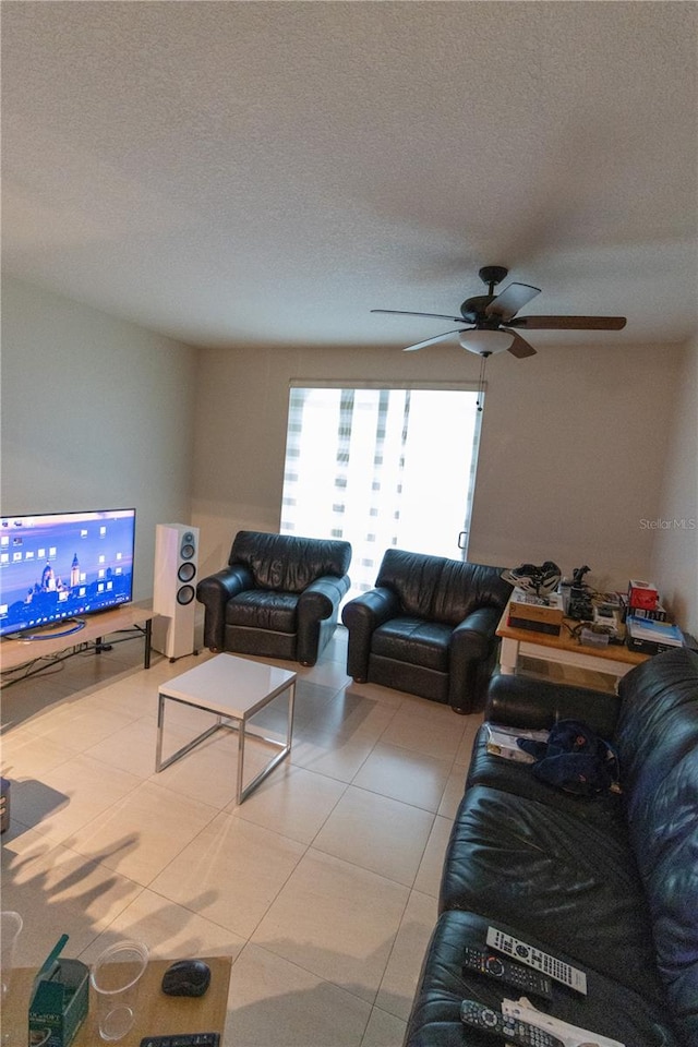 living room with light tile patterned floors, a textured ceiling, and ceiling fan