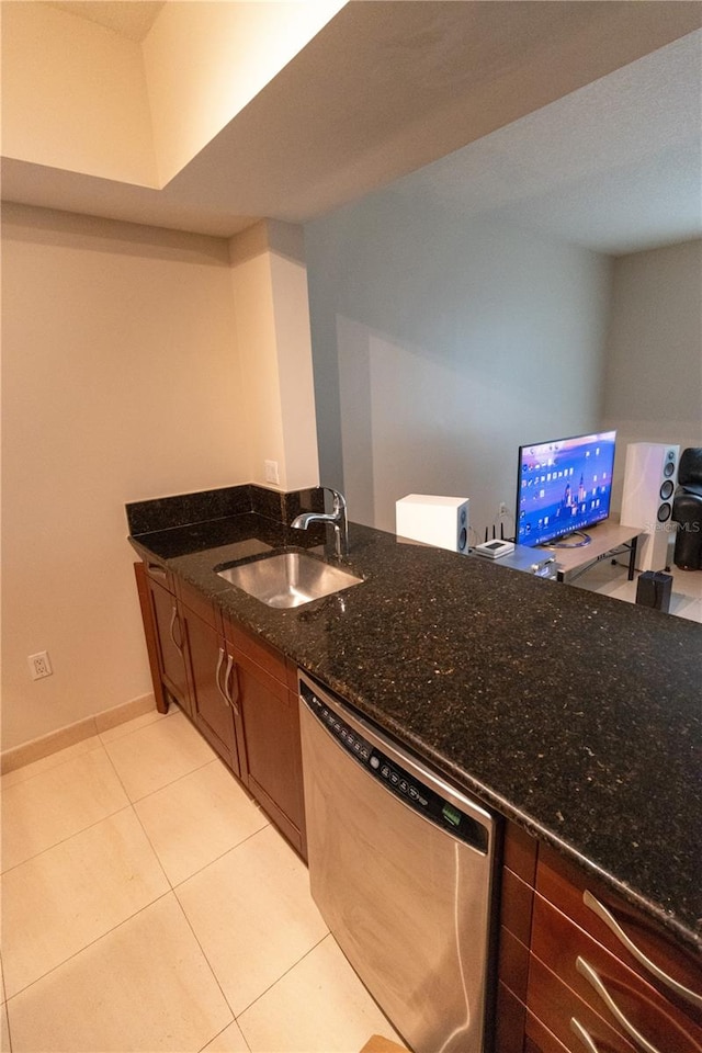 kitchen featuring light tile patterned floors, dark stone counters, sink, and stainless steel dishwasher