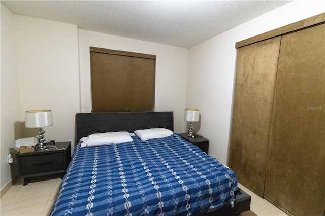 bedroom with a textured ceiling and light tile patterned floors