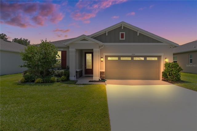 view of front of house with a garage and a yard