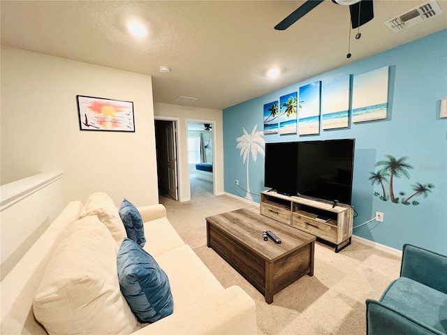 carpeted living room featuring a textured ceiling and ceiling fan