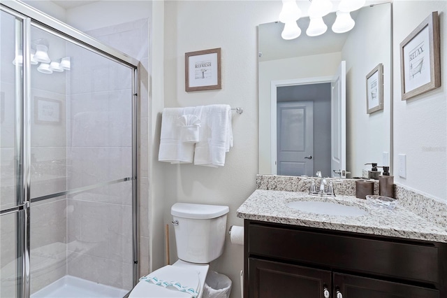 bathroom with toilet, walk in shower, and vanity