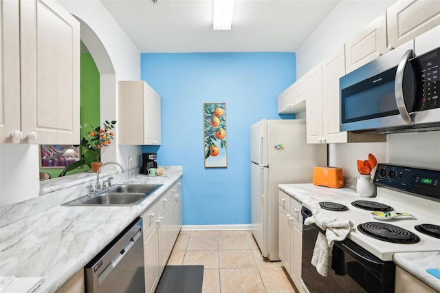 kitchen featuring stainless steel appliances, white cabinetry, light tile patterned floors, and sink