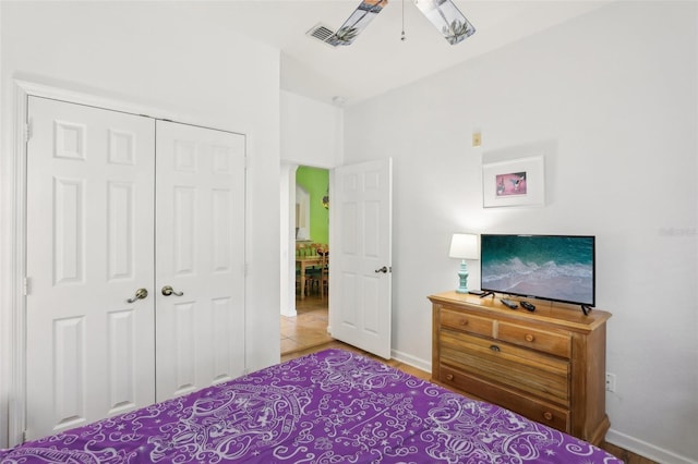 tiled bedroom featuring ceiling fan and a closet