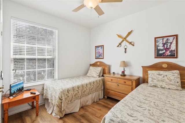 bedroom with ceiling fan, hardwood / wood-style flooring, and multiple windows