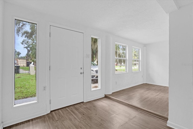 interior space with a textured ceiling and light hardwood / wood-style flooring