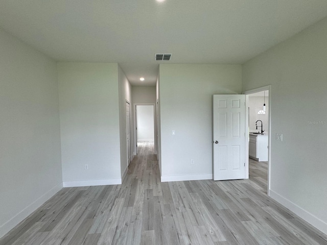 spare room with light hardwood / wood-style flooring and sink