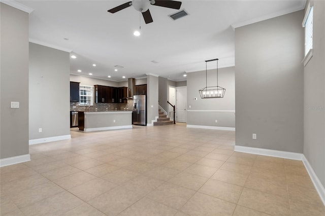 unfurnished living room with ornamental molding, light tile patterned floors, and ceiling fan with notable chandelier