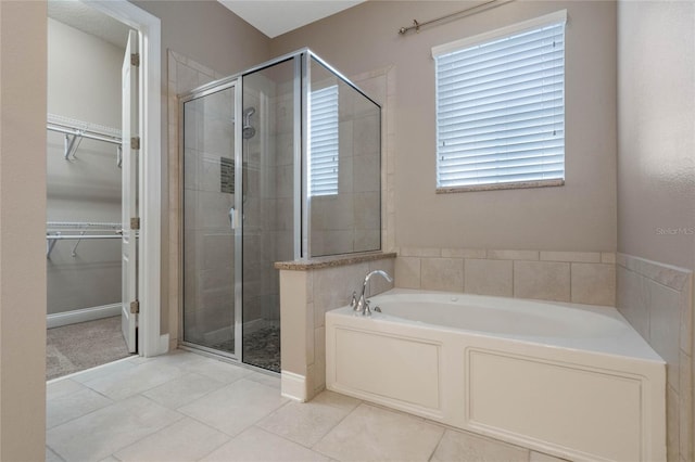 bathroom with independent shower and bath and tile patterned floors