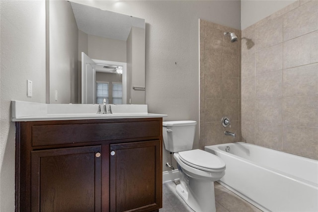 full bathroom featuring ceiling fan, vanity, tiled shower / bath combo, tile patterned flooring, and toilet