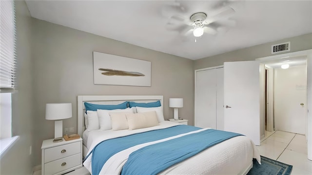 tiled bedroom with ceiling fan and a closet