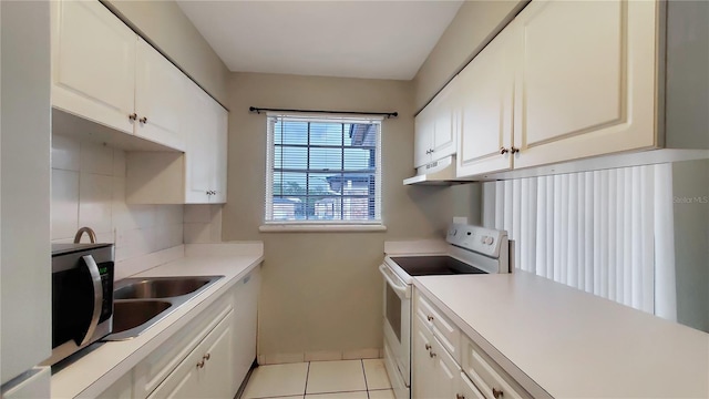 kitchen featuring white electric stove, sink, light tile patterned floors, and white cabinets